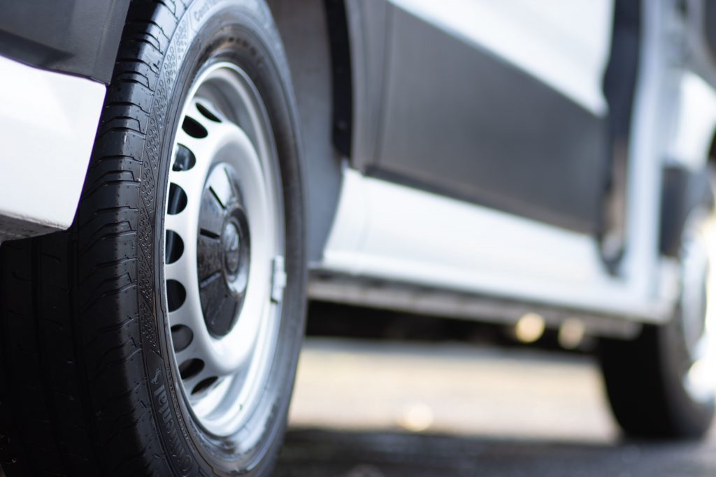 A close-up of a wheel of a refrigerated vehicle.