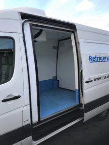 Open side door of a white VW Crafter refrigerated van.